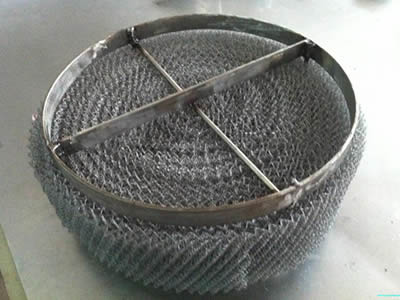 A piece of demister pad with round bar and flat strip supporting grid on the table.