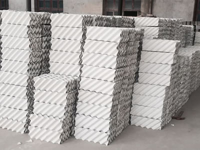 Several ceramic structured packing modules are piled in the warehouse.