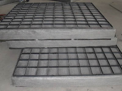 Three rectangular demister pads are piled on the ground.