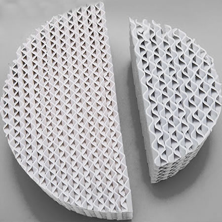 Two pieces of plate plastic structured packing in different diameter on the gray background.