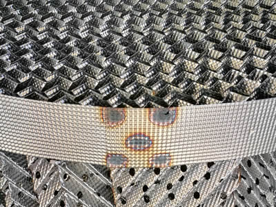 L'emballage ondulé à plaque perforée en métal présente de nombreux trous sur une plaque ondulée.